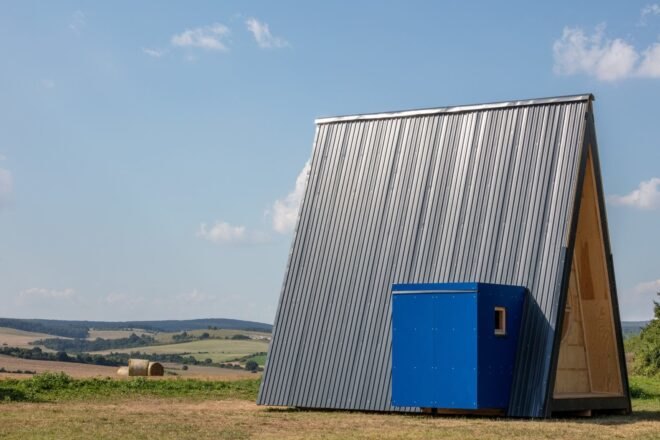 tiny cabin with dark exterior and blue wooden box