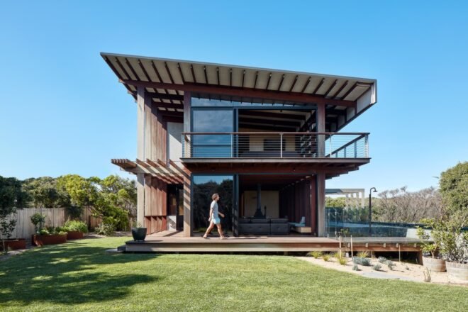 person walking on patio wrapped around a two-story home