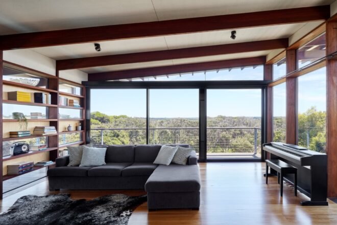 dark sofa near built-in bookshelves and a piano