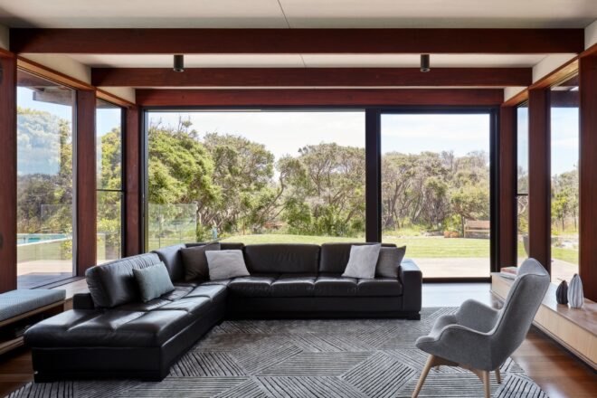 black leather sectional sofa near walls of glass