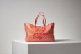 red tote bag on white cube