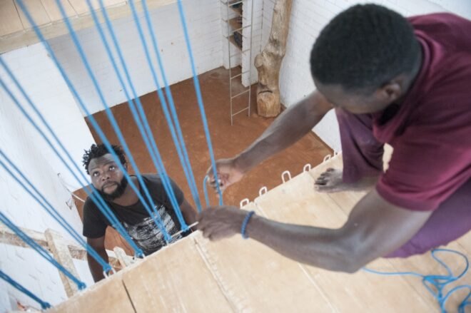 people adding blue barriers at the edge of a loft
