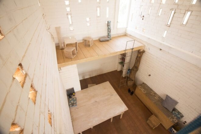 aerial view of wooden platforms inside a building made from earth bricks