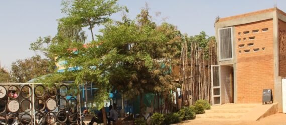 dirt path leading to tall building made from earth bricks