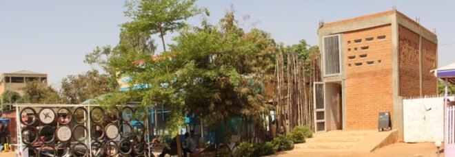 dirt path leading to tall building made from earth bricks