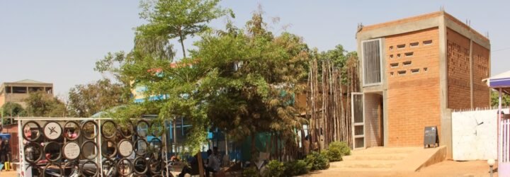dirt path leading to tall building made from earth bricks