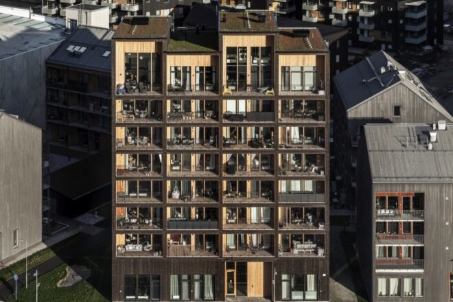 tall dark wood building with several large windows and balconies