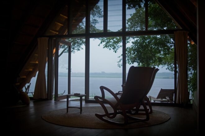 a quiet seating area with single chair looking out over a river