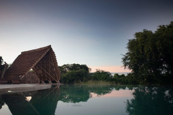 a pitched roof structure on the bank of a river