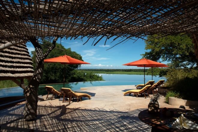 outdoor pool with lounge chairs and red umbrellas