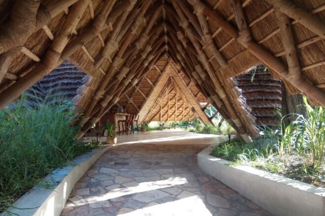 a winding walkway covered in thatched roof