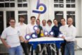 a group of people in white shirts (the Odd.Bot team), holding cutout letters that spell 