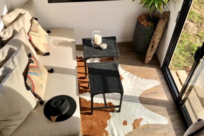 tiny home living space with sofa and black metal tables