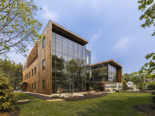 a large glass facade building surrounded by wood panels