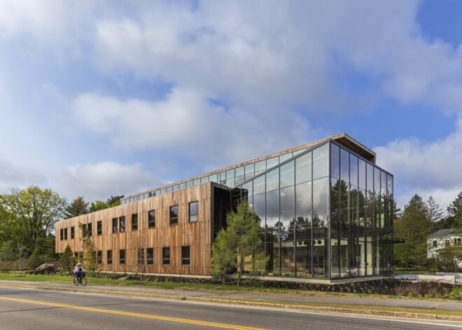 a building with one half of the facade covered in wood and the other made of glass