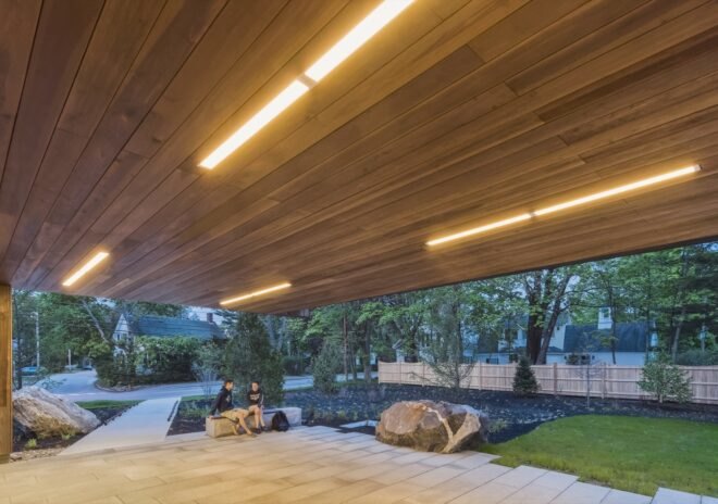a wood panel overhead strcuture covers a lobby area where people sit