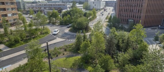 a large green city space surrounded by roads and tall buildings