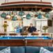 three people behind a blue billiards table