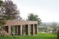 brick home built into green slope