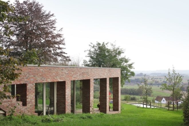 brick home built into green slope