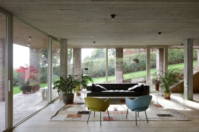 blue and yellow chairs and dark sofa in room with glass walls