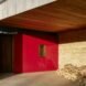 a red entranceway with a pile of wood stacked off to the side
