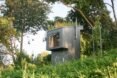 black outhouse with grassy roof