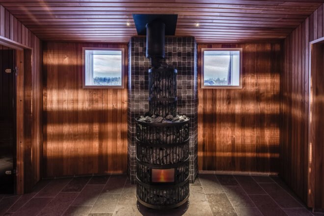 a sauna space with central stone heating unit