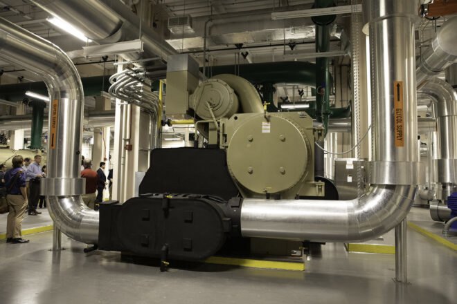 interior of a factory-like area, featuring the back of a black machine