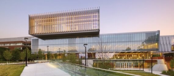 large glass college building at dusk