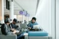 students on laptops sitting in blue and gray chairs