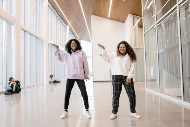 students dancing in a well-lit hallway