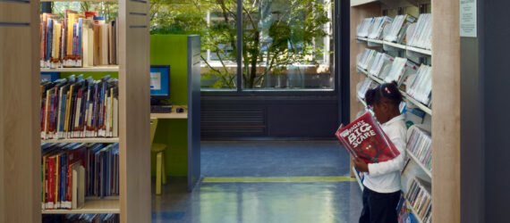 child reading a book in a library