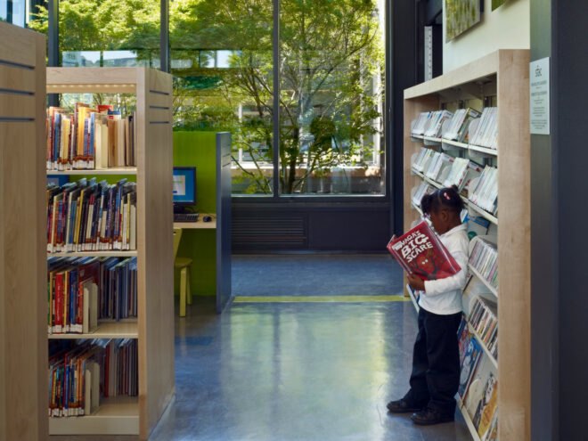 child reading a book in a library