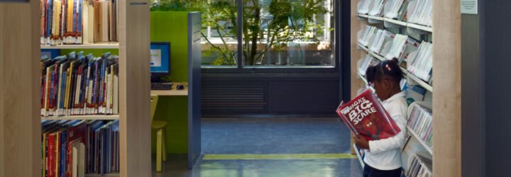 child reading a book in a library