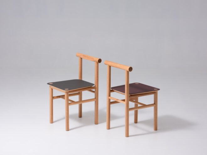 two oak wood chairs with black and red seats