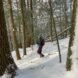 person snowshoeing downhill in a snowy landscape