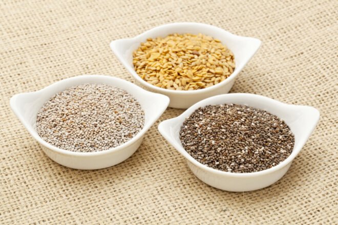 chia and flax seeds in white bowls on burlap