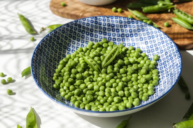 fresh shelled green peas in a blue bowl