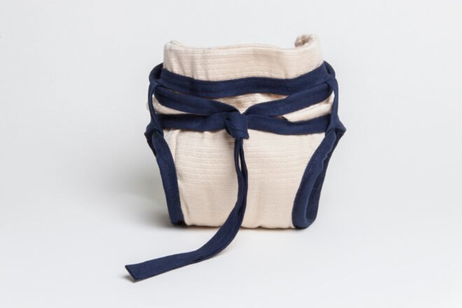 tan reusable diaper with blue ties around the waist