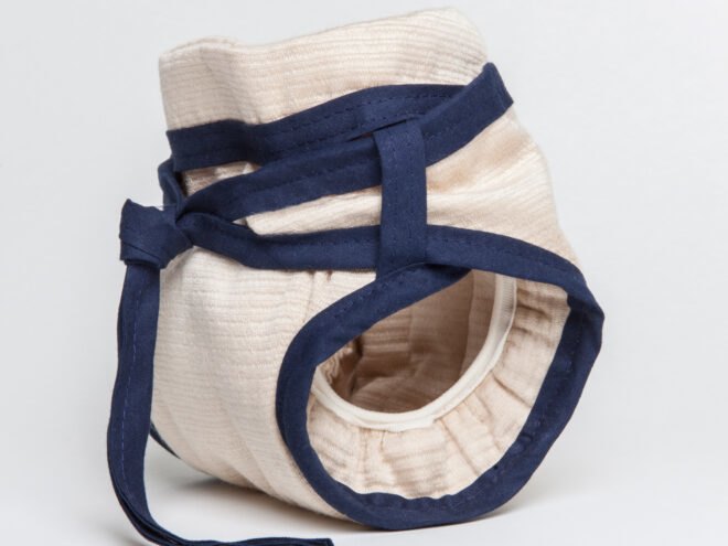 side view of tan reusable diaper with blue ties around the waist