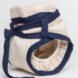 side view of tan reusable diaper with blue ties around the waist