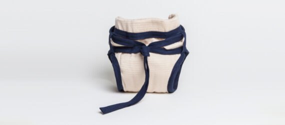 tan reusable diaper with blue ties around the waist