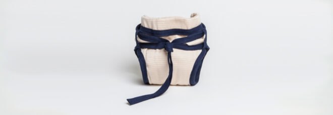 tan reusable diaper with blue ties around the waist