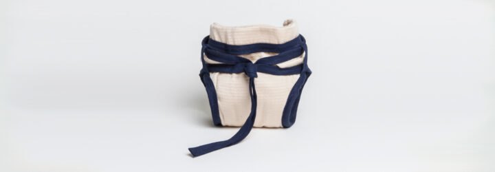 tan reusable diaper with blue ties around the waist
