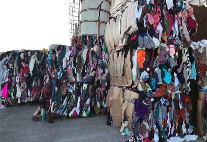 stacked of bounded recycled clothes at a landfill