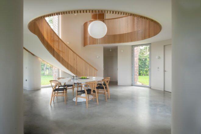 circular home interior with spiral staircase and a small dining table