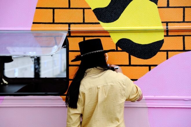 a man in a hat painted the exterior of a camper