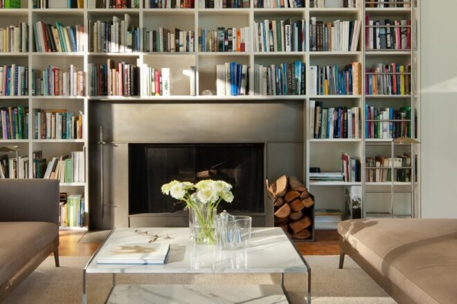 a wall of built-in shelves built around a fireplace
