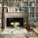 a wall of built-in shelves built around a fireplace